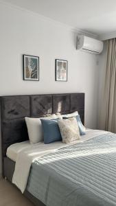 een slaapkamer met een groot bed met blauwe en witte kussens bij Квартира в отличном районе с евро ремонтом in Alma-Ata