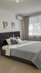 ein Schlafzimmer mit einem großen Bett mit blauen Kissen in der Unterkunft Квартира в отличном районе с евро ремонтом in Almaty