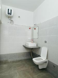 a bathroom with a toilet and a sink at Atithya in Udaipur