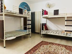 a room with two bunk beds and a rug at Atithya in Udaipur