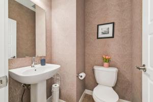 a bathroom with a white toilet and a sink at Brand New 3-Bedroom Home in a Quiet Neighborhood in Calgary