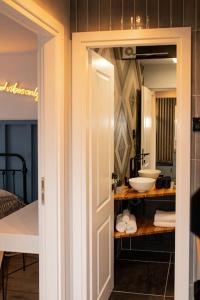 uma casa de banho com um lavatório e uma porta que dá acesso a um quarto em blue moon. cozy apartment near Iulius Mall em Cluj-Napoca