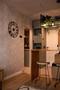 uma cozinha com um relógio na parede e um banco em blue moon. cozy apartment near Iulius Mall em Cluj-Napoca