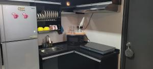 una piccola cucina con lavandino e frigorifero di Ipoh homestay Casa a Ipoh