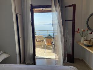 a bedroom with a door open to a balcony at Hotel Barbati Sea View B&B in Barbati