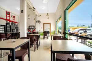 a restaurant with tables and chairs and a car outside at OYO Life 1299 Balcony Orange Homestay in Palembang