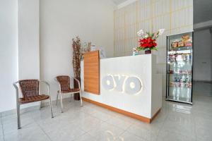 aiya store with two chairs and a counter and a refrigerator at OYO Life 1299 Balcony Orange Homestay in Palembang