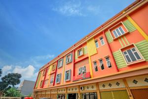 a colorful building with many windows on the side of it at OYO Life 1299 Balcony Orange Homestay in Palembang