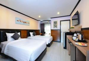 Habitación de hotel con 2 camas y TV en The Breton Hotel Media en Bangkok