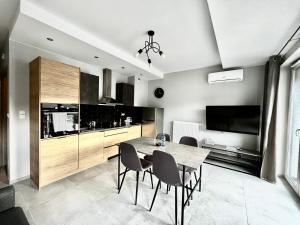 a kitchen and dining room with a table and chairs at City Center Apartments z parkingiem in Bydgoszcz