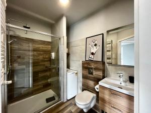 a bathroom with a toilet and a sink and a shower at City Center Apartments z parkingiem in Bydgoszcz +25 photos