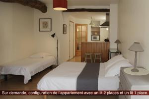 a bedroom with two beds and a kitchen in the background at maison La Marche in Cugand +13 photos