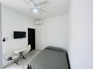 a bedroom with a bed and a ceiling fan at Mini Departamento Real del Country Playa Alberca in Manzanillo