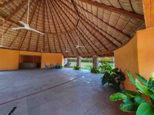a large patio with a large straw roof at Mini Departamento Real del Country Playa Alberca in Manzanillo