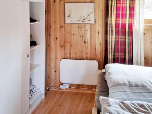 ein Schlafzimmer mit Holzwänden und ein Bett in einem Zimmer in der Unterkunft Holiday home Bratland 