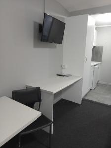 una oficina con escritorio y TV en la pared en Solomon Inn Motel Figtree en Wollongong