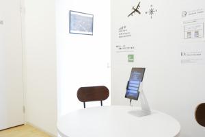 Pokój ze stołem, krzesłem i tabletem w obiekcie Lodging Tokyo Uguisudani w Tokio