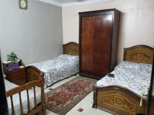 a bedroom with two beds and a wooden door at شقة مفروشة in Cairo