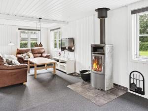 sala de estar con chimenea y sofá en 6 person holiday home in F rvang en Fårvang