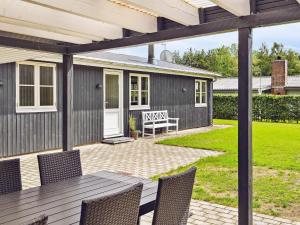 a patio with a table and chairs and a house at 6 person holiday home in F rvang in Fårvang