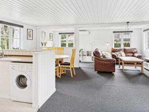 a kitchen and a living room with a washing machine at 6 person holiday home in F rvang in Fårvang