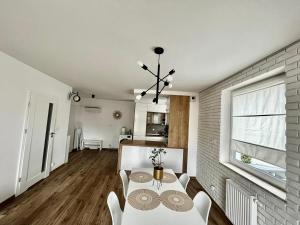 uma sala de estar com uma mesa e cadeiras e uma janela em City Center Apartments z parkingiem em Bydgoszcz
