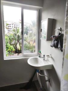 a bathroom with a sink and a window at Comfort Family Homestay in Guwahati +29 photos