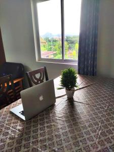 a laptop computer sitting on a table with a potted plant at Comfort Family Homestay in Guwahati