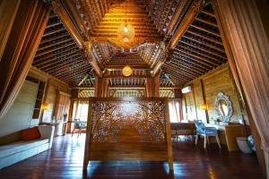 sala de estar con techo de madera y sofá en Ubud Riverside Villa, en Ubud