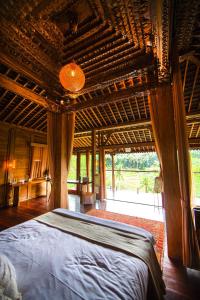 1 dormitorio con 1 cama grande y techo de madera en Ubud Riverside Villa, en Ubud