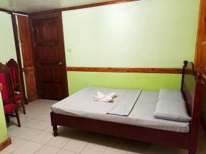 Cama en habitación con pared verde en Regular Room in Casa de Piedra Pension House 