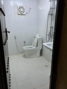 a bathroom with a toilet and a tub and a sink at Mall Aldakhil House in Al Ḩamrāʼ