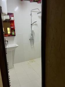 uma casa de banho com um chuveiro e um lavatório. em Mall Aldakhil House em Al Hamra