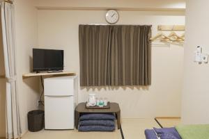 a living room with a tv and a table with a table at Lodging Tokyo Shibamata in Tokyo