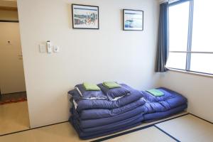 東京にあるLodging Tokyo Shibamataの窓付きの客室で、青い大型ソファが備わります。