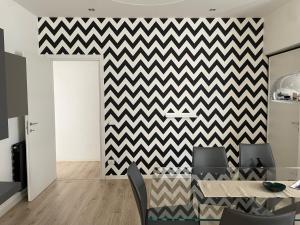 a dining room with a chevron wall at Aci Boutique Apartment in Acitrezza
