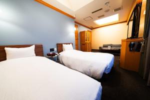 a hotel room with two beds and a flat screen tv at ORDA HOTEL in Chiba
