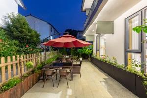 a patio with a table and chairs and an umbrella at Hangzhou Ziwei Boutique Homestay in Hangzhou