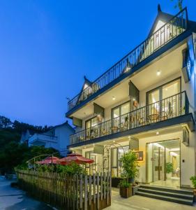 a large white building with balconies and umbrellas at Hangzhou Ziwei Boutique Homestay in Hangzhou