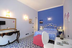 1 dormitorio con cama, tocador y espejo en Auditorium Rooms en Ravello