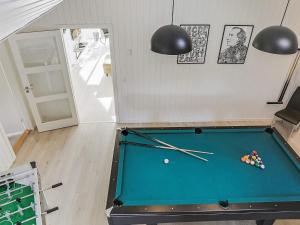 a room with a pool table with cue balls at 14 person holiday home in Idestrup in Marielyst