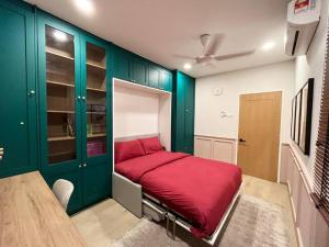a red bed in a room with green cabinets at The Celery Homestay @PPAM Saderi - Cozy&Homey in Putrajaya