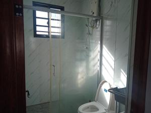 a bathroom with a toilet and a glass shower door at Apartment in Port Moresby - Short Stays in Port Moresby +11 photos