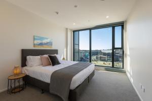 a bedroom with a large bed and a large window at Luxury 2 Bedroom CBD Apartment with Free Parking in Christchurch