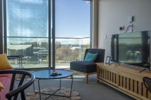 a living room with a flat screen tv and a couch at Luxury 2 Bedroom CBD Apartment with Free Parking in Christchurch