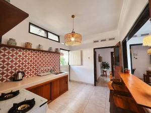 cocina con fregadero y fogones en Kamudi Jogja Guesthouse, en Ngabean