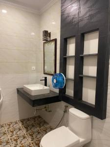a bathroom with a white toilet and a sink at Plumerrata in Phnom Penh