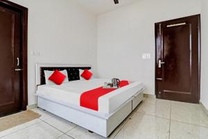 a bedroom with a bed with red and black pillows at OYO Flagship Hotel Royal Inn in Patiāla