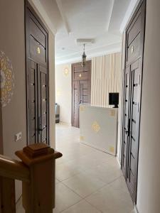 pasillo con puertas negras y suelo de baldosa en Elite Boutique, en Samarkand