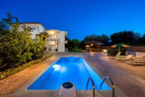 una piscina di fronte a una casa di notte di Villa Rea Luxury 5 bdrs with swimming pool a Kremasti